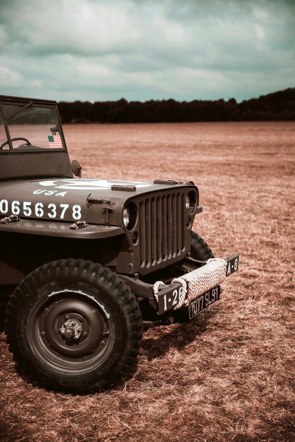 an old jeep is parked in a field