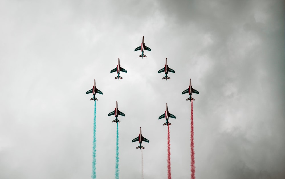 a group of fighter jets flying through a cloudy sky