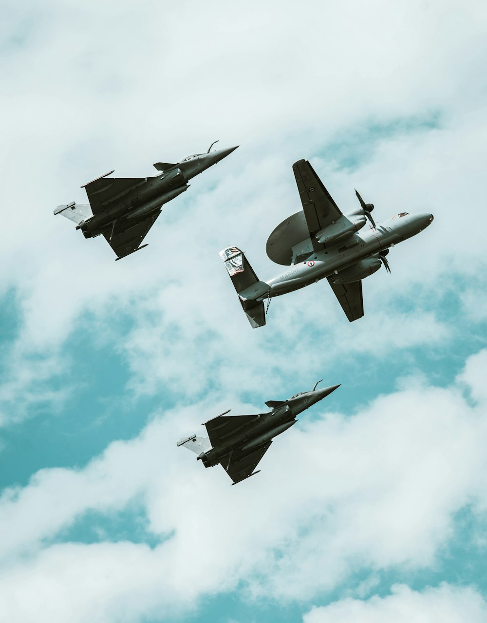 Un gruppo di aerei da combattimento che volano attraverso un cielo nuvoloso