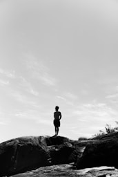 a man standing on top of a large rock