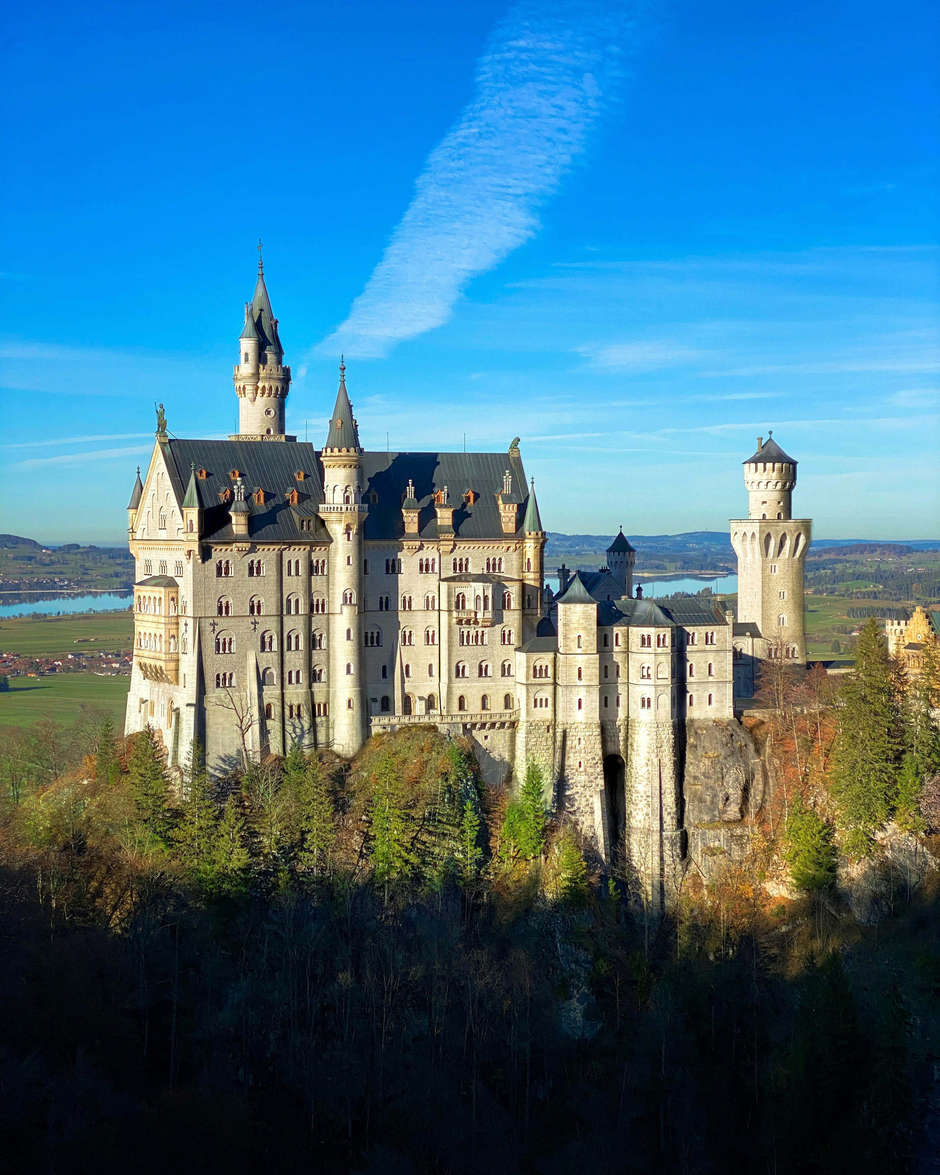 A castle on a hill with Neuschwanstein Castle in the