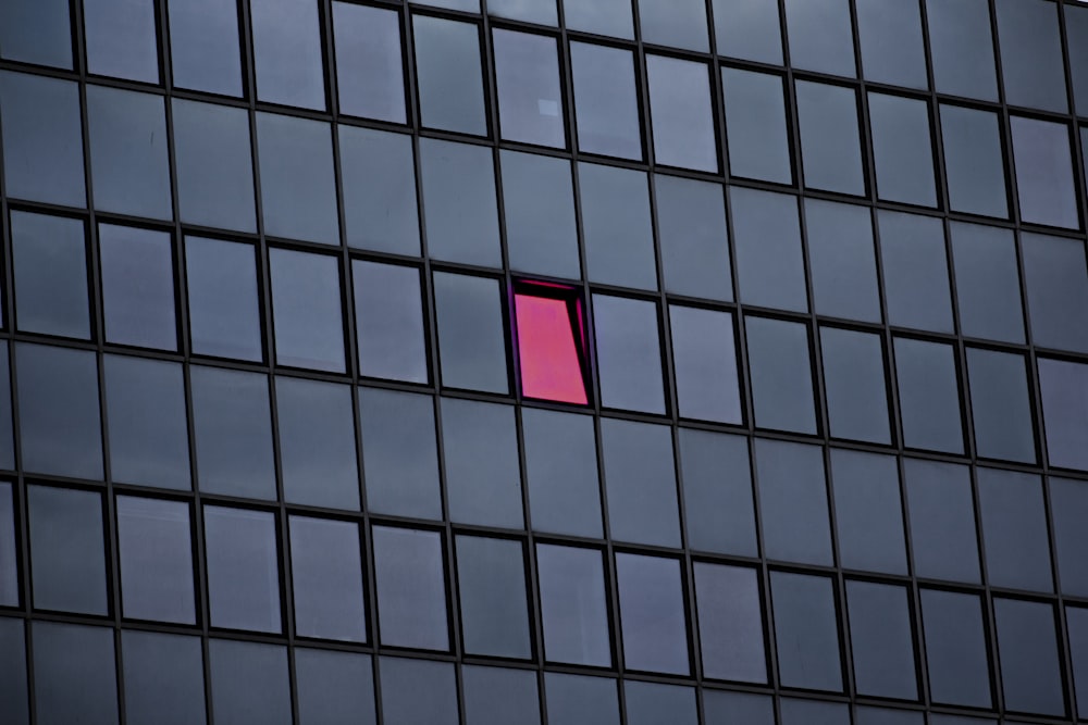 a pink window in a building with a sky background