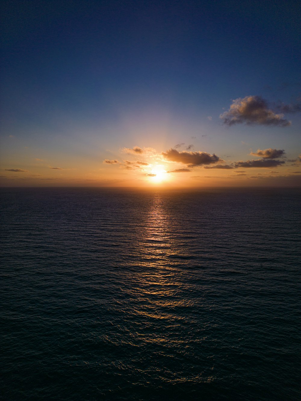 a large body of water with a sunset in the background