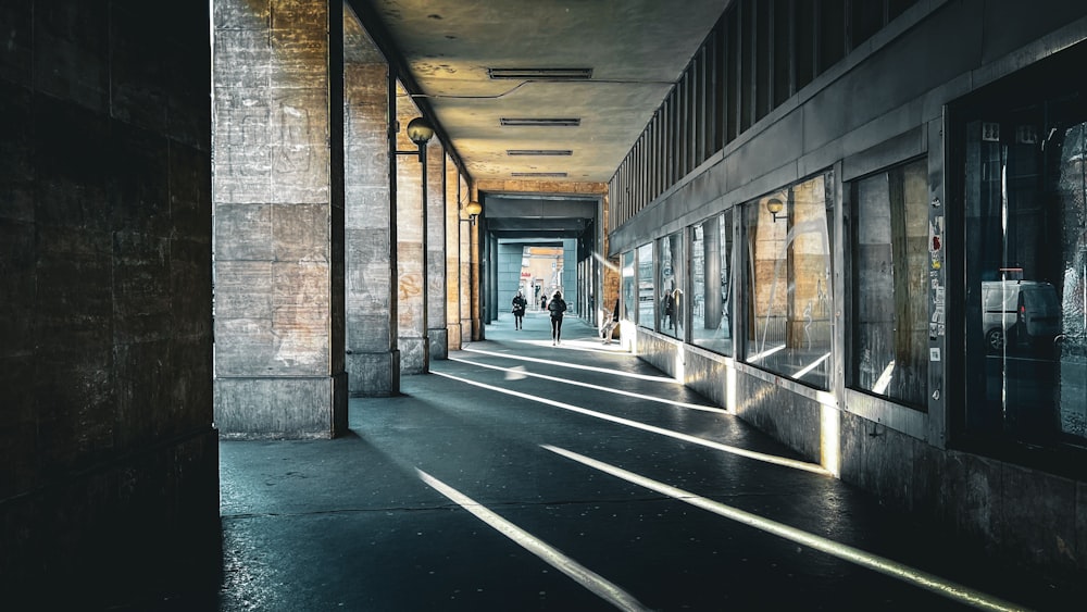 a long hallway with a couple of people walking down it