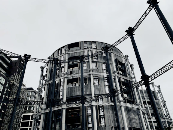 A modern commercial building framed with steel beams under a grey sky.