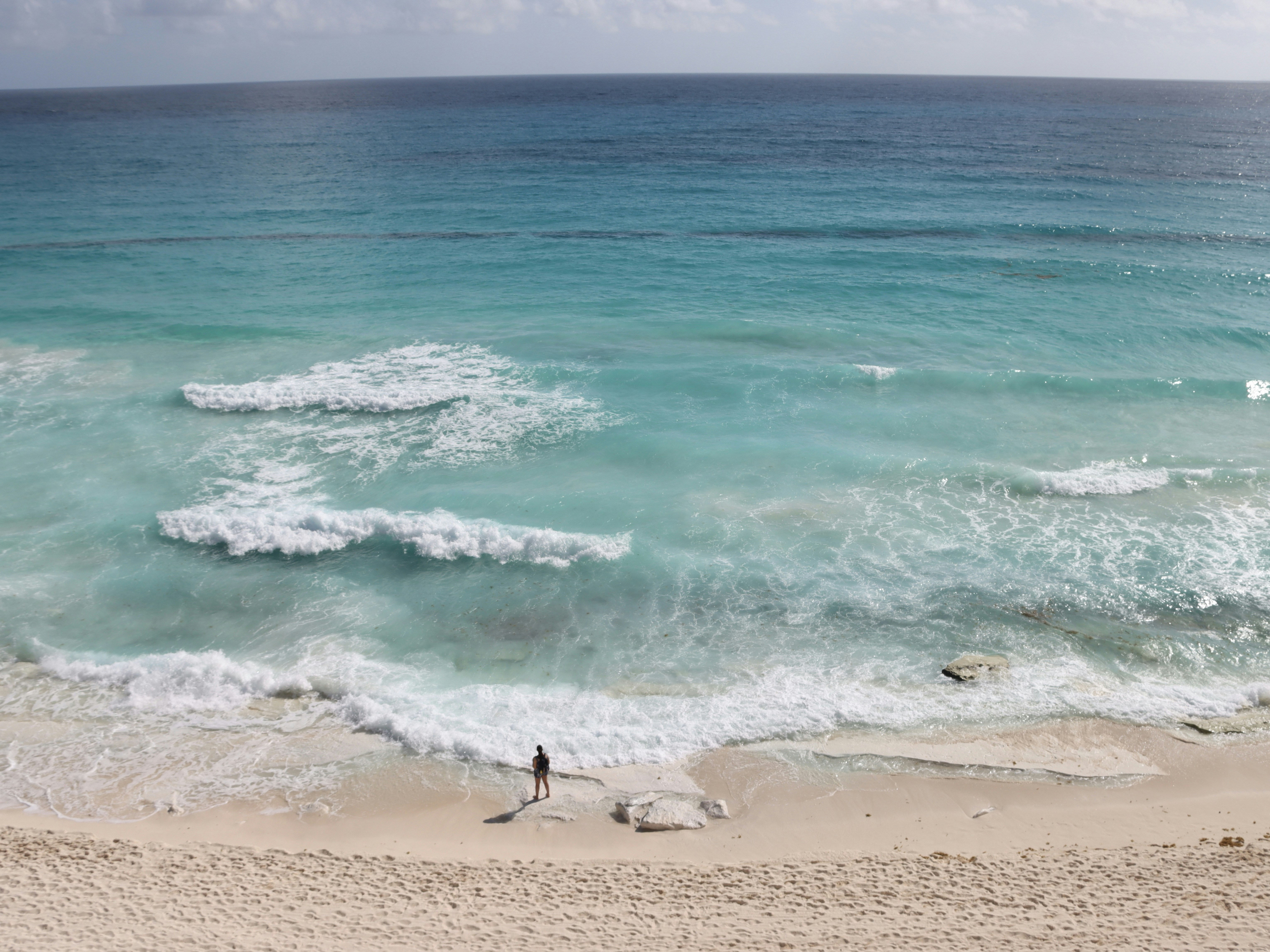 a person standing on a beach next to the ocean