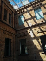 Bright interior courtyard with concrete walls, wooden decking, and natural light flooding in.