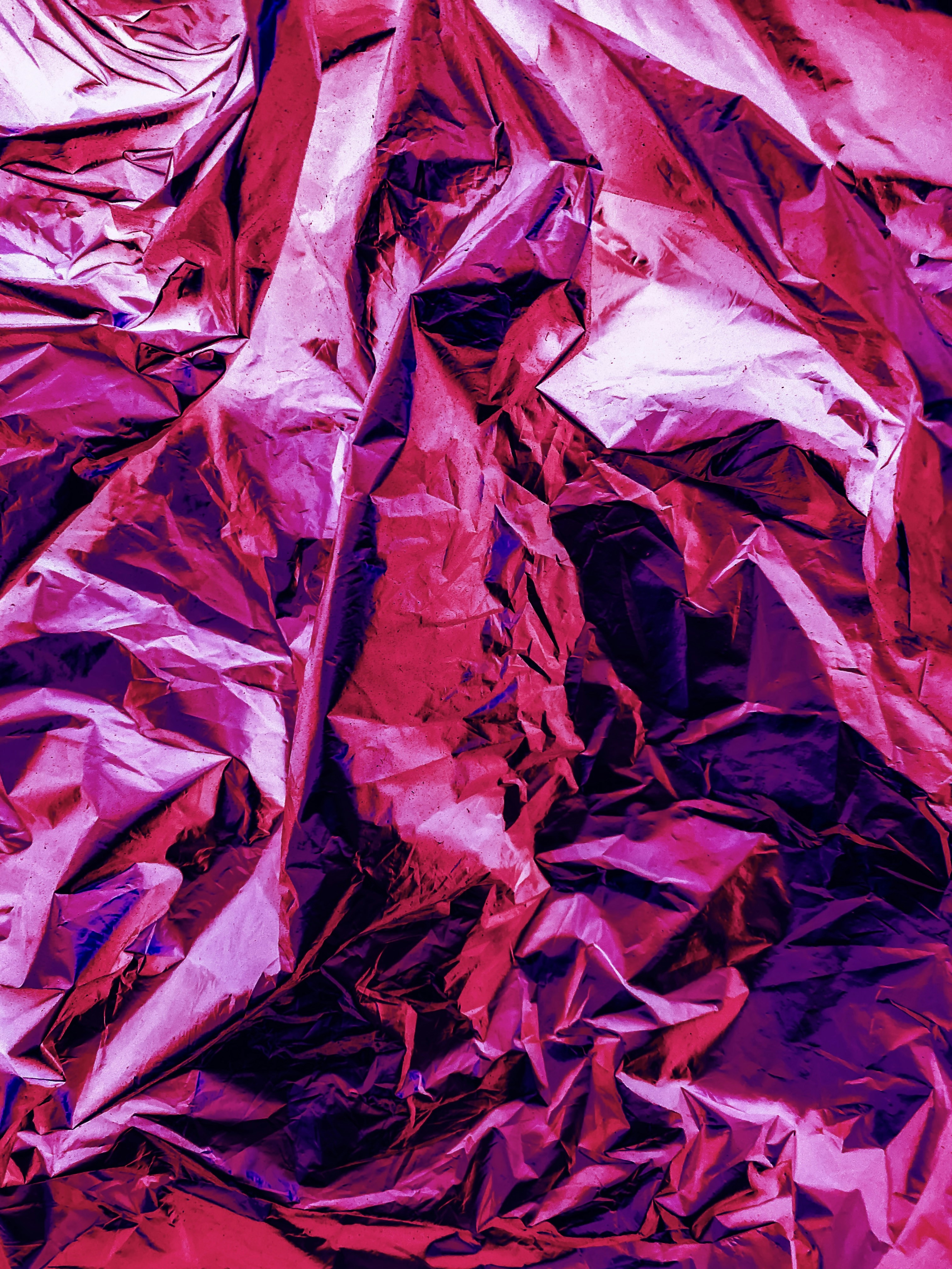 une pile de papier froissé violet posé sur une table