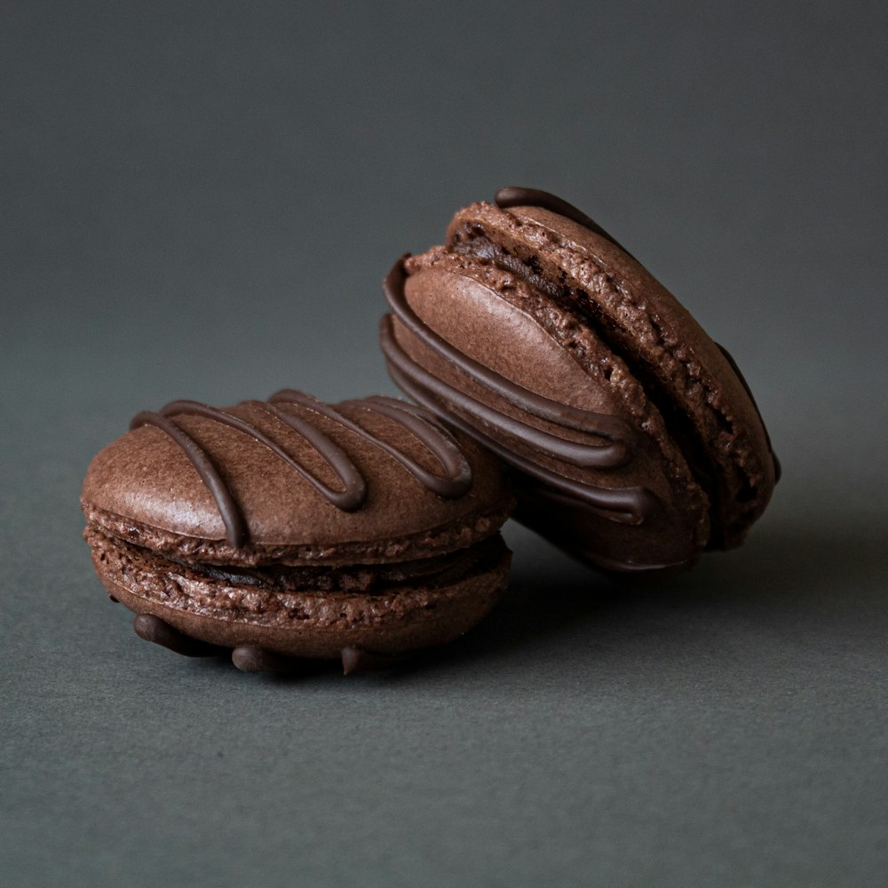 two chocolate macaroons sitting on top of each other