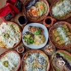 a table topped with lots of plates of food
