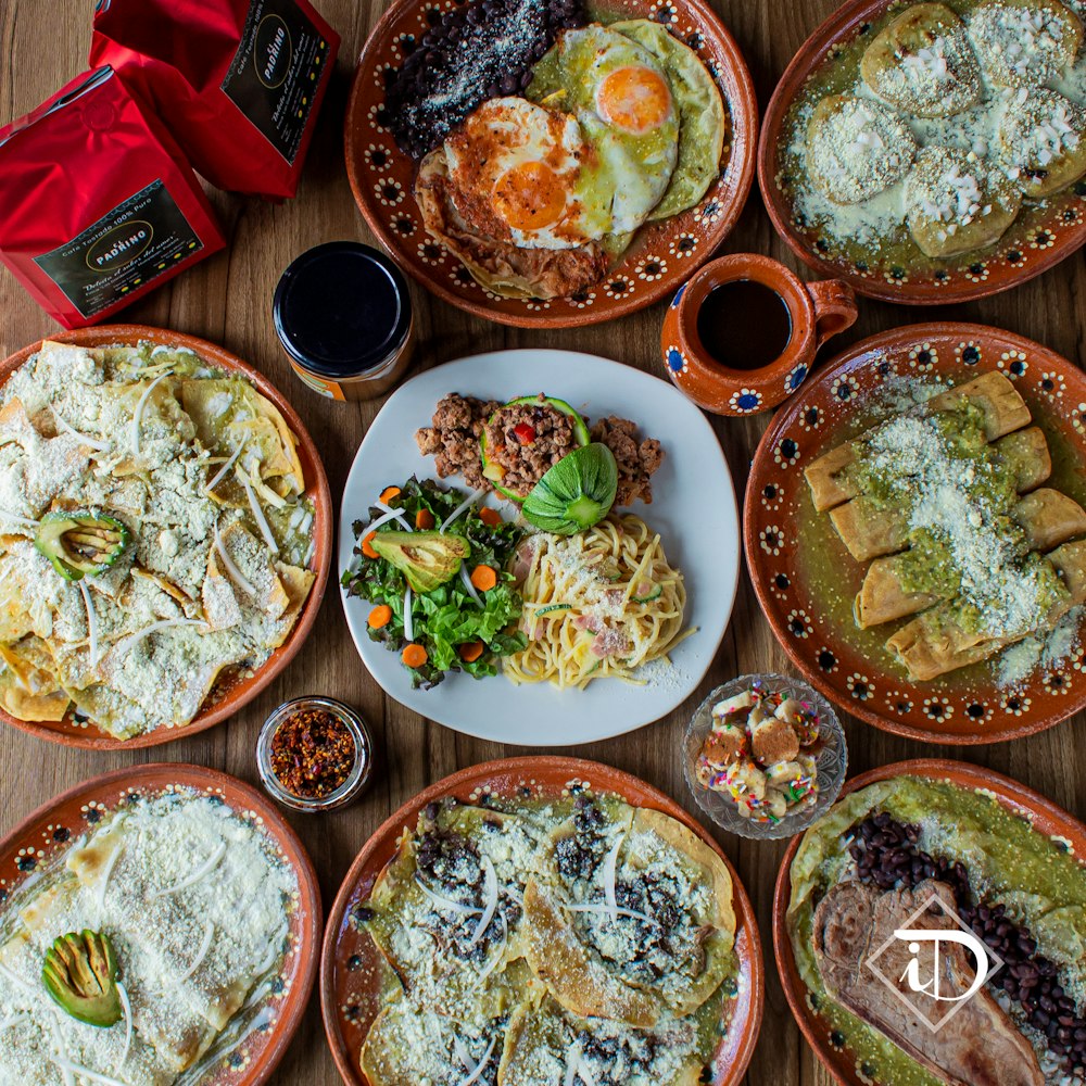 a table topped with lots of plates of food
