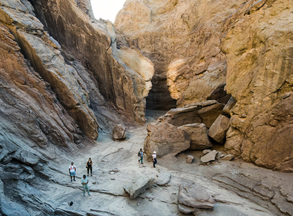 a group of people walking through a narrow canyon