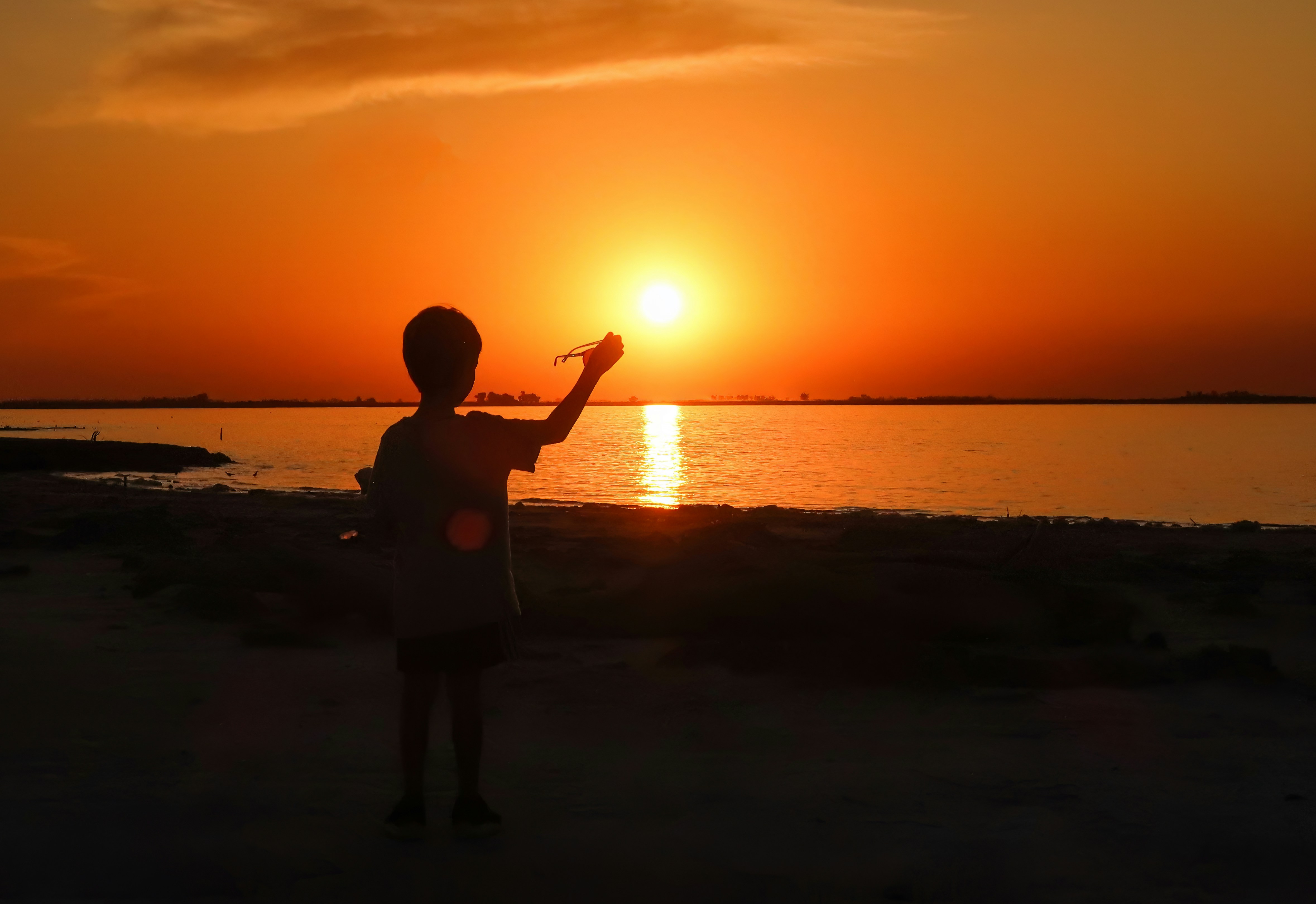 a person standing on a beach at sunset