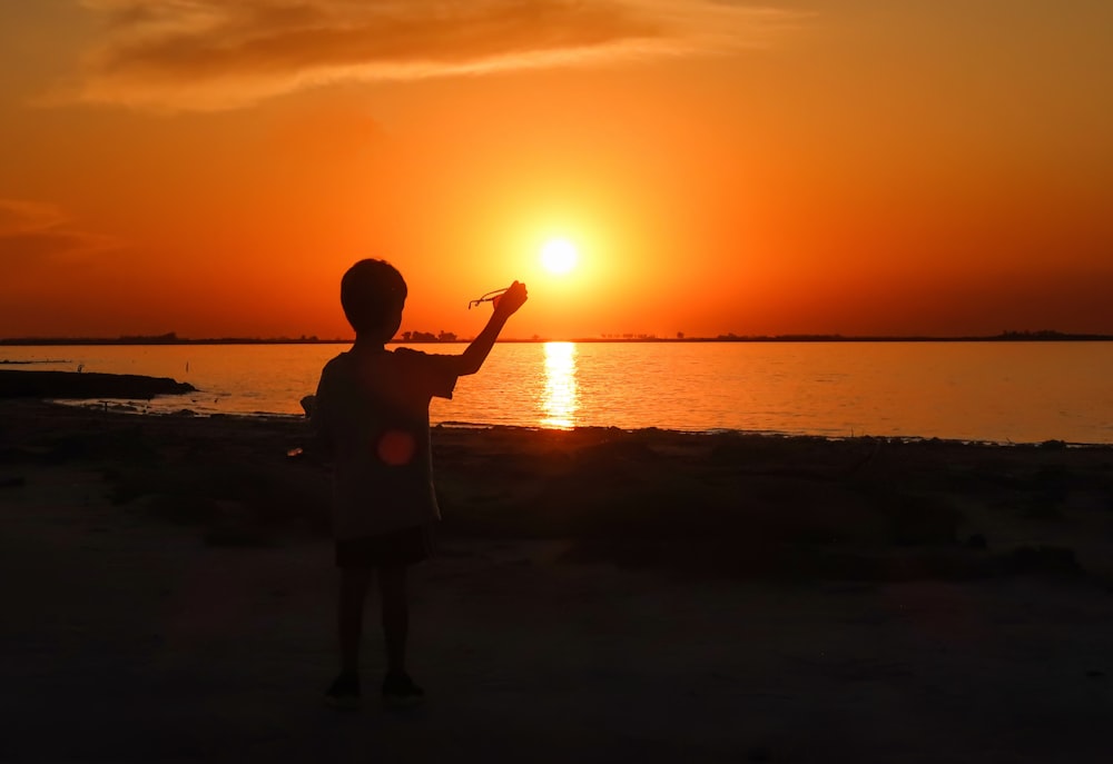 a person standing on a beach at sunset