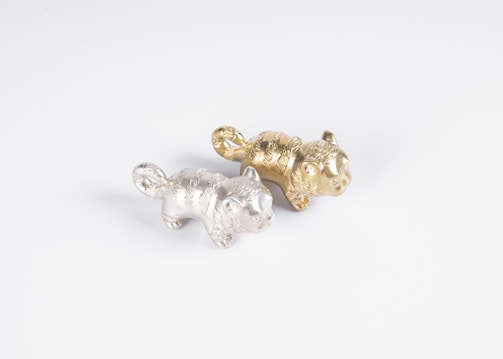 A premium, modern pet figurine set against a minimalist black and gold background.
