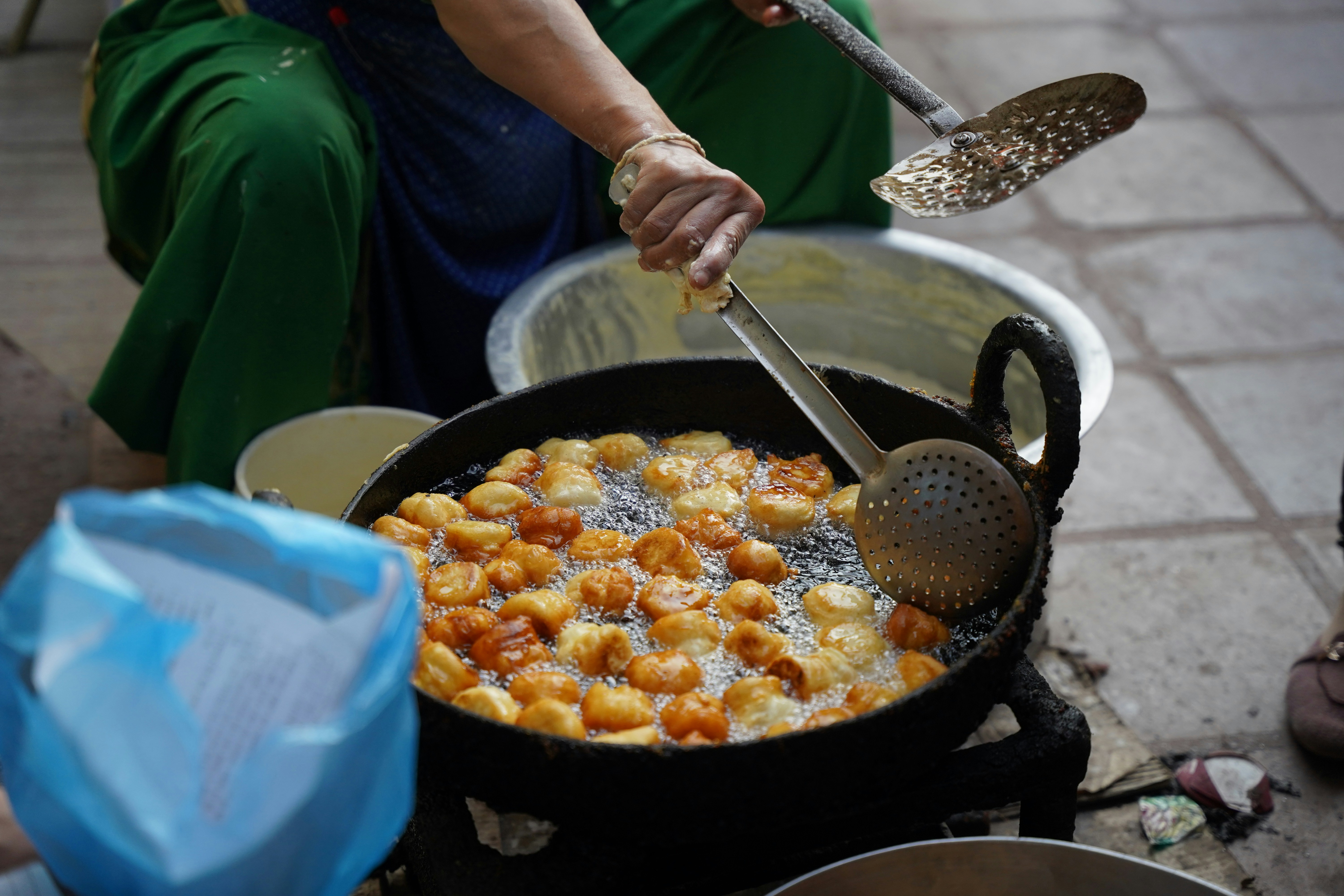 a woman is cooking food in a large skillet
