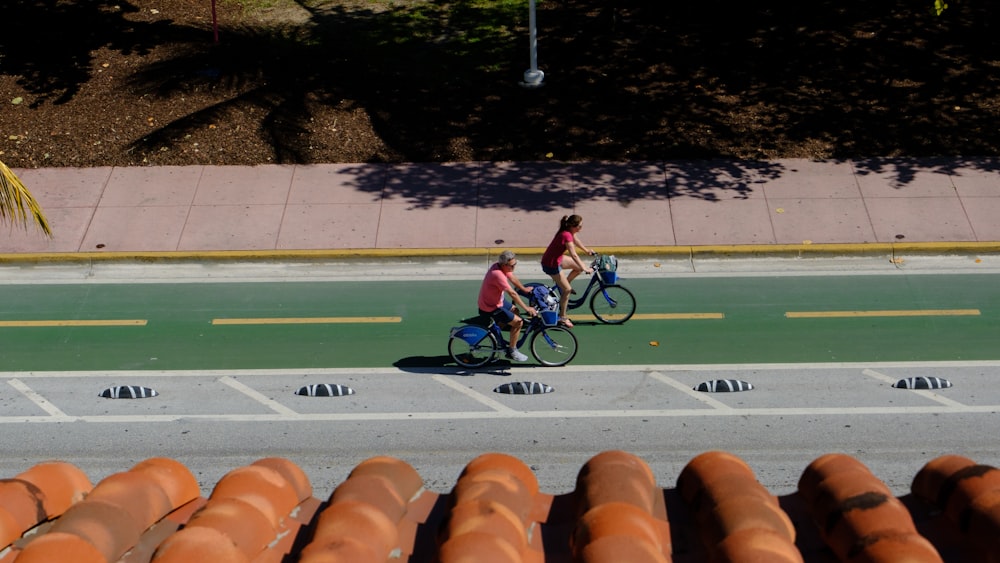 a couple of people riding bikes down a street