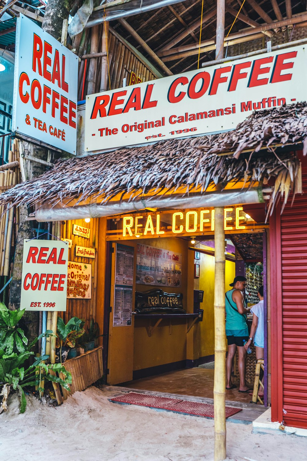 a couple of people standing outside of a coffee shop