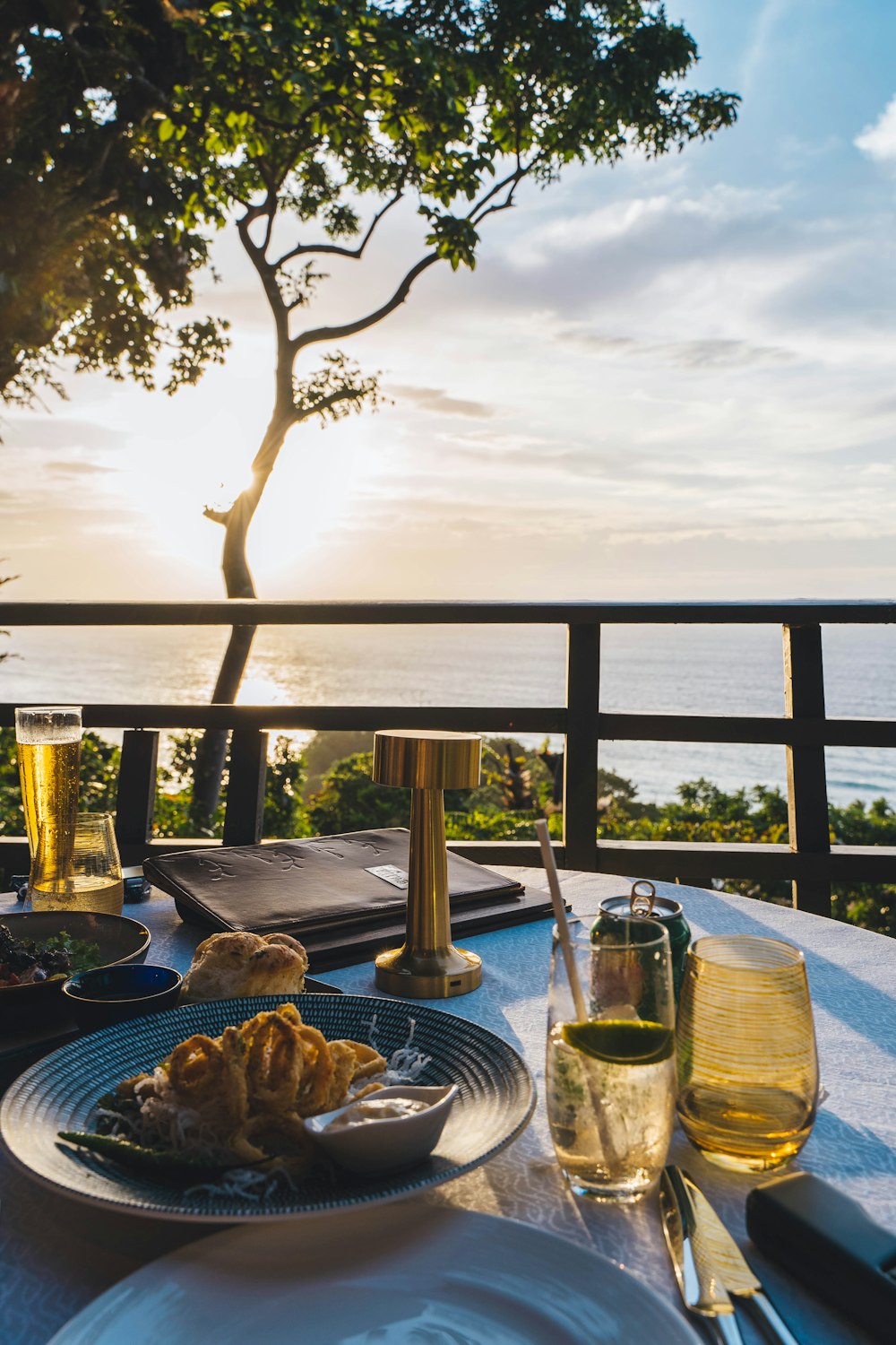 a plate of food on a table with a view of the ocean