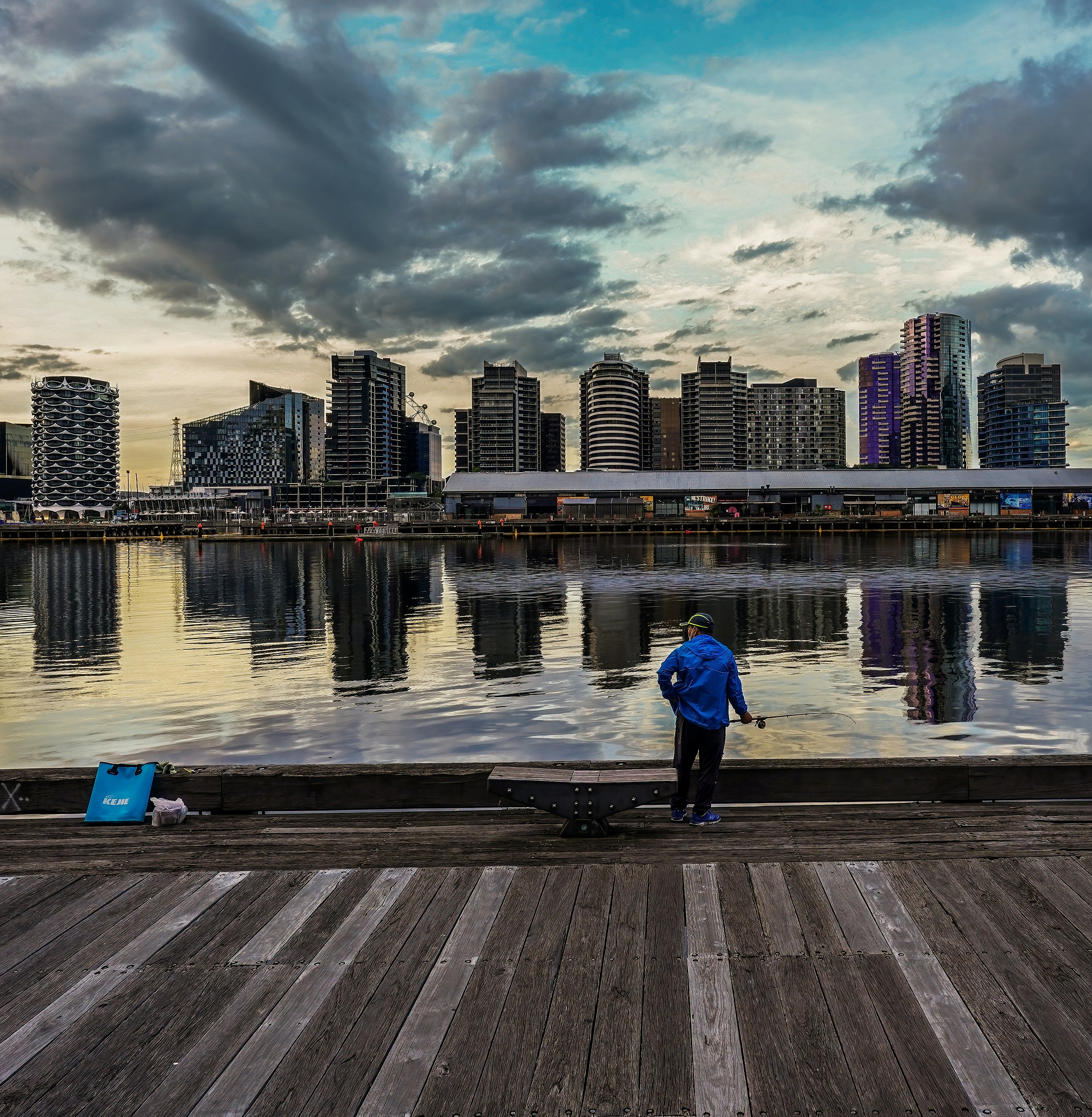 a man standing on a dock next to a body of water