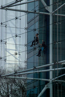a man climbing up the side of a tall building
