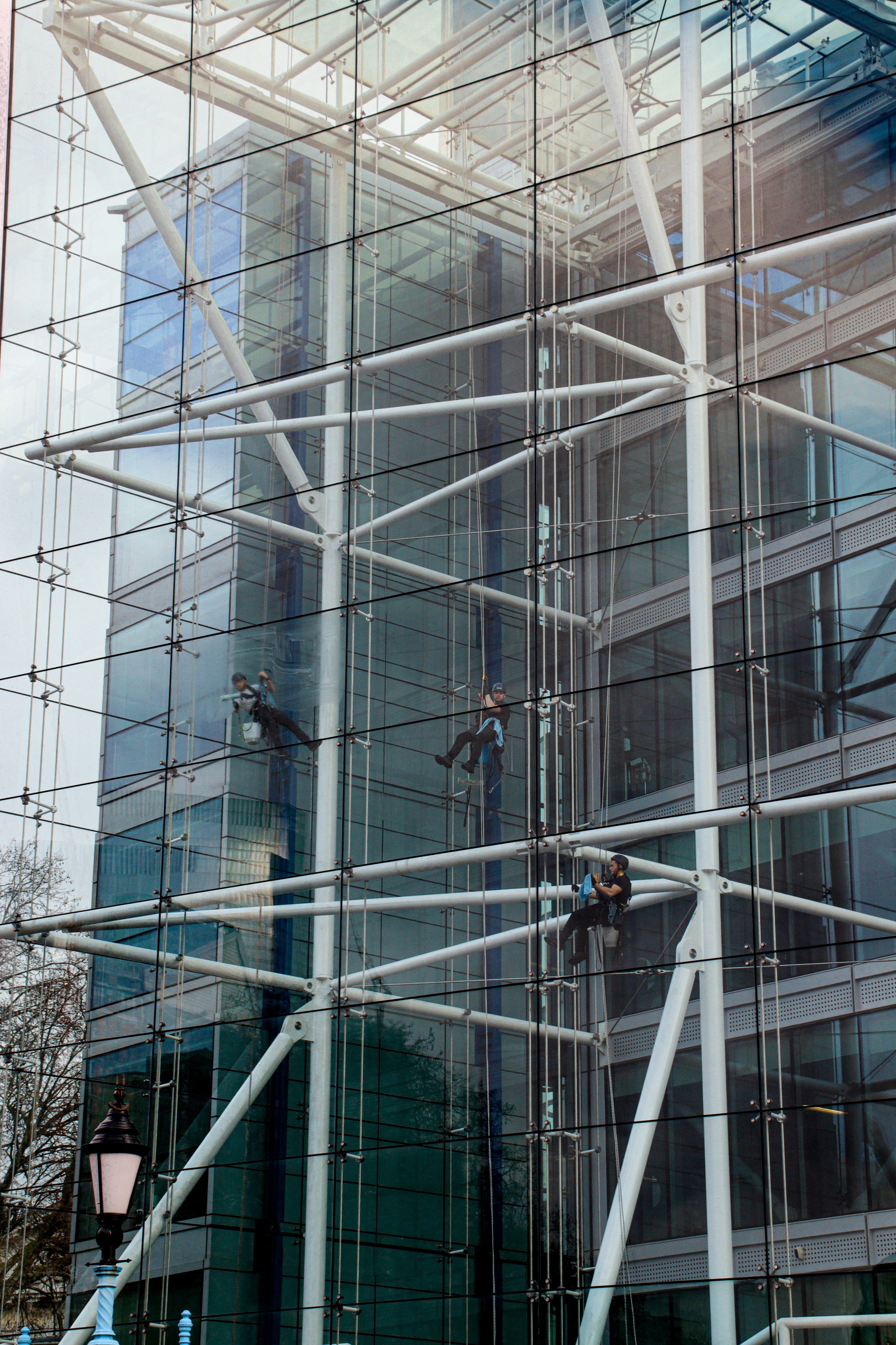 Window cleaner's working from ropes on the inside of a Tower Bridge House London