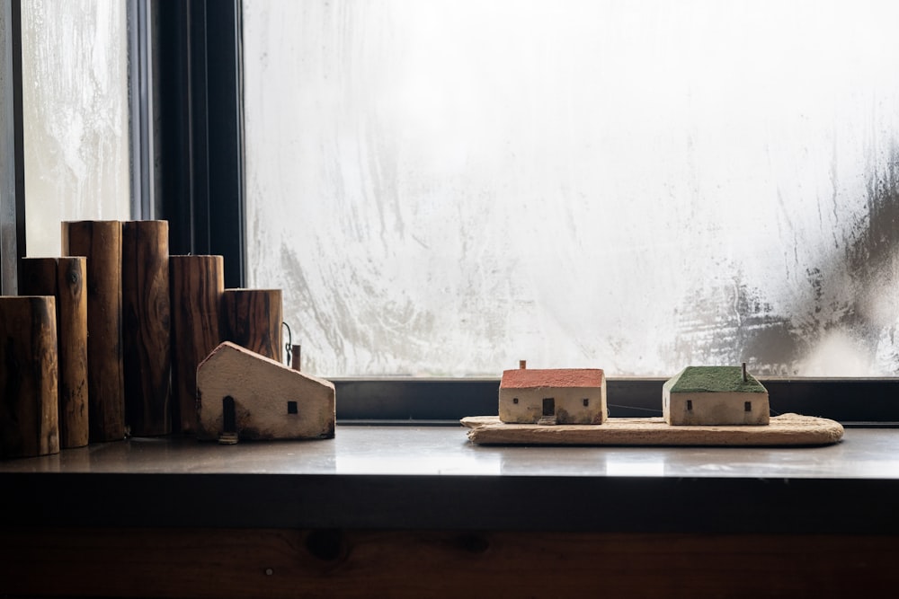 a couple of small houses sitting on top of a wooden table