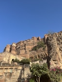 a castle on top of a hill with a blue sky in the background