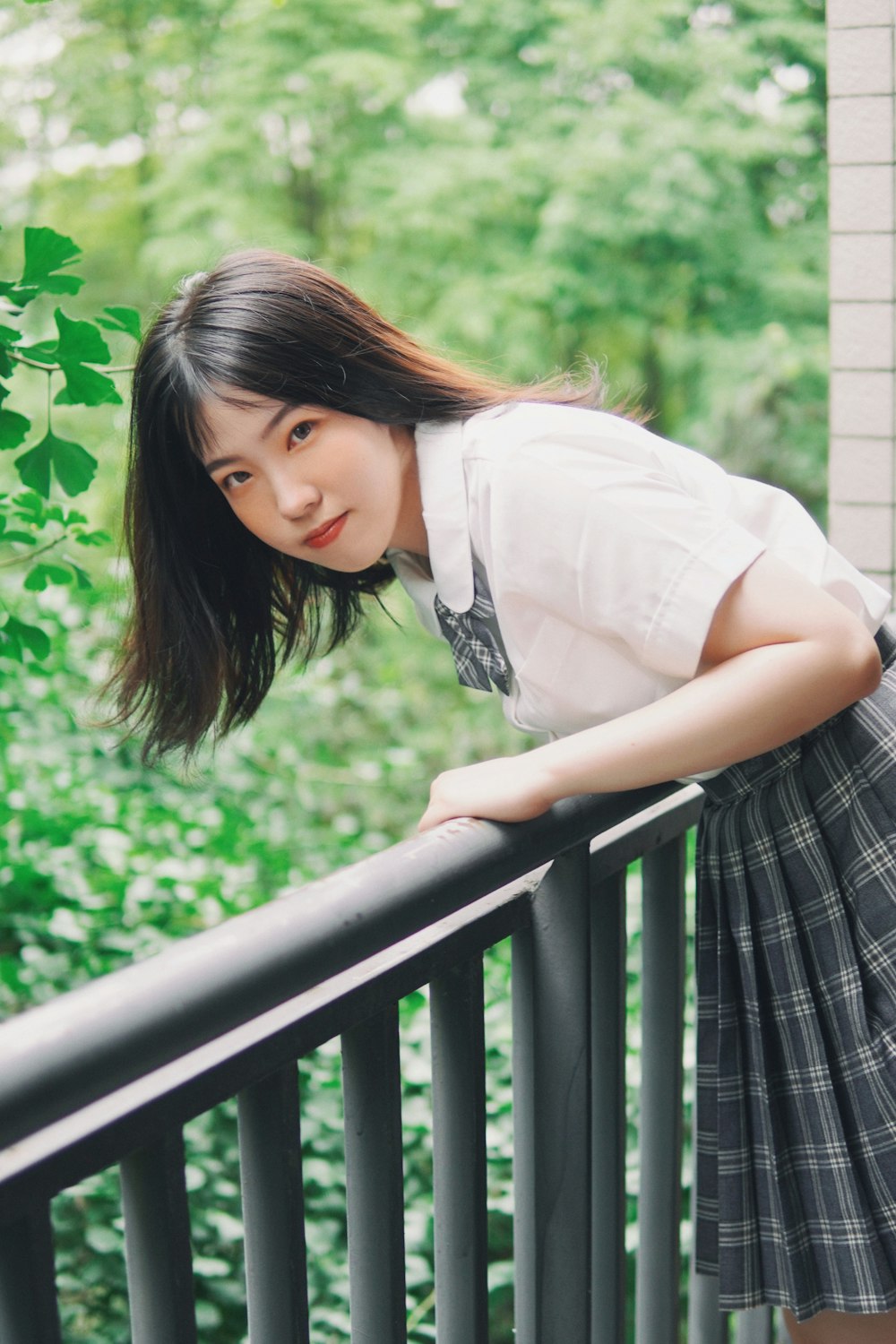 a young woman leaning on a balcony rail