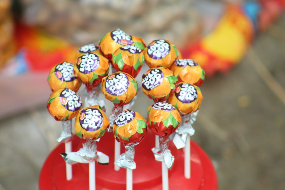 a bunch of lollipops sitting on top of a red stand