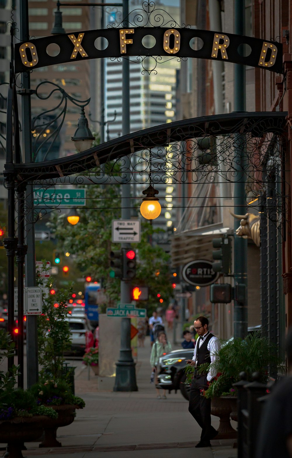 a man walking down a street next to tall buildings