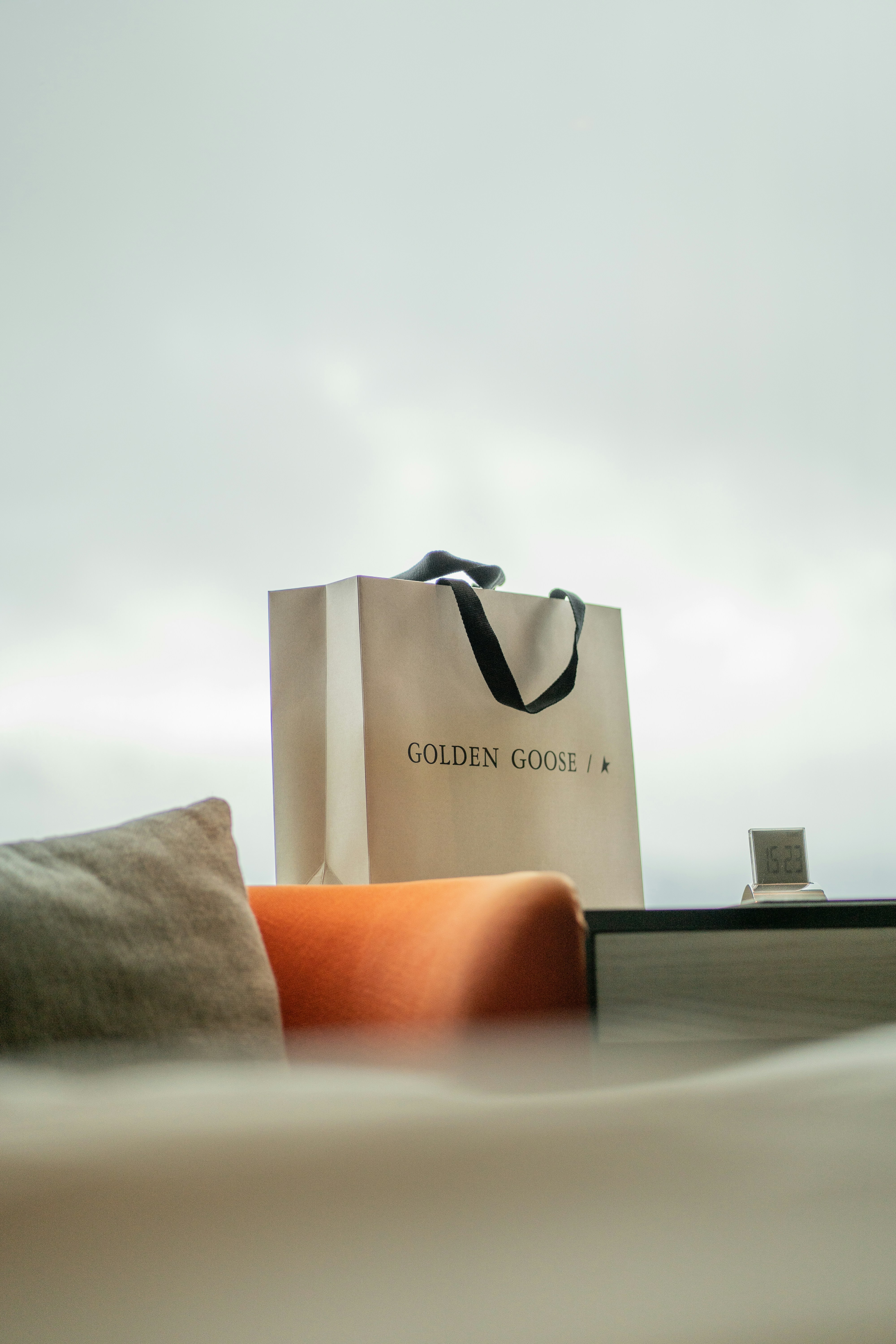 Una bolsa encima de una cama junto a una almohada