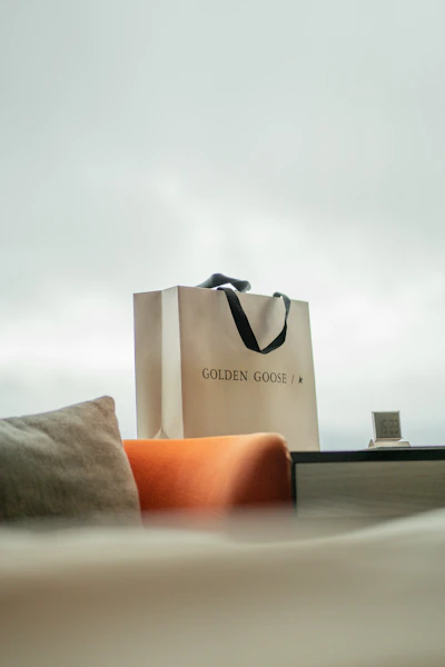 a bag sitting on top of a bed next to a pillow