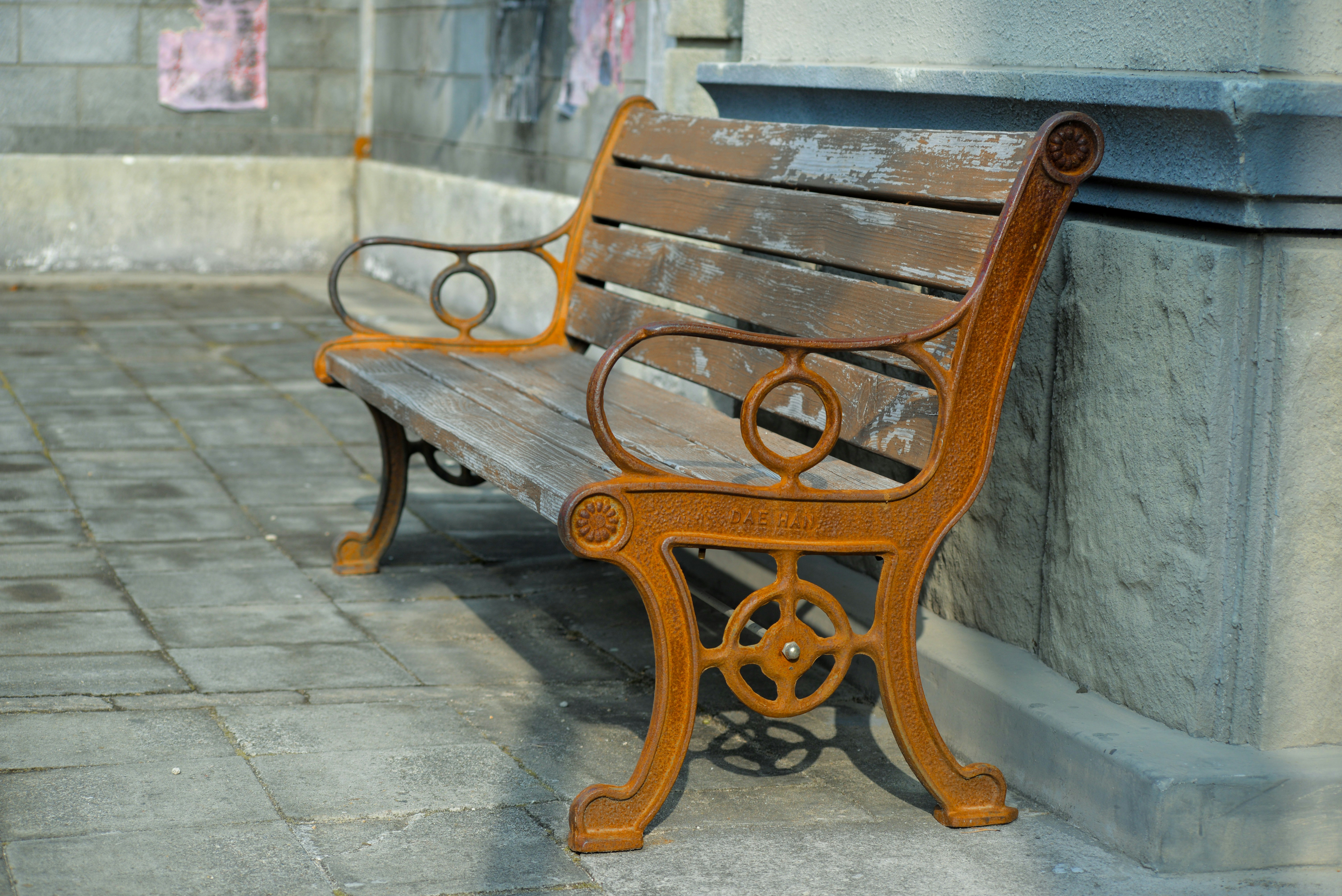 a wooden bench sitting on the side of a building