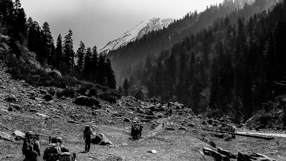 a black and white photo of people hiking up a mountain