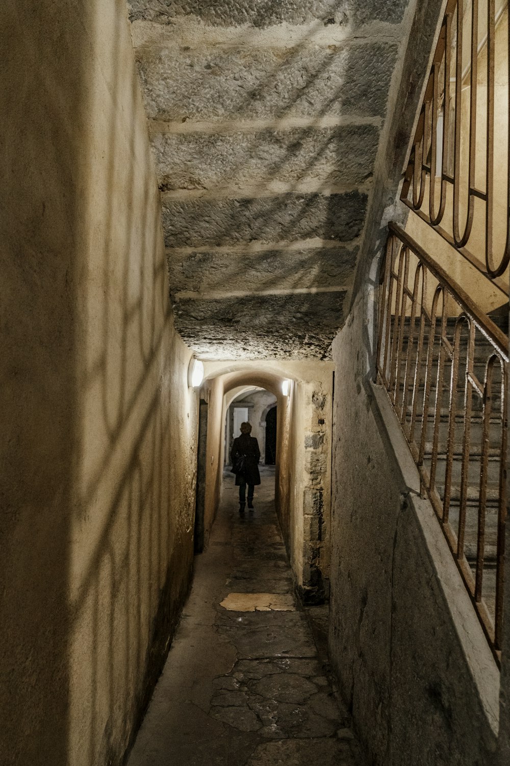 two people walking down a long narrow hallway