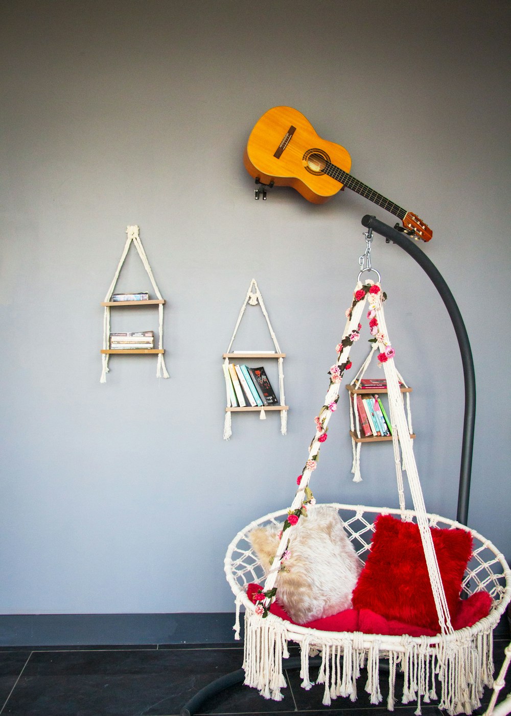 a guitar hanging on the wall next to a hammock