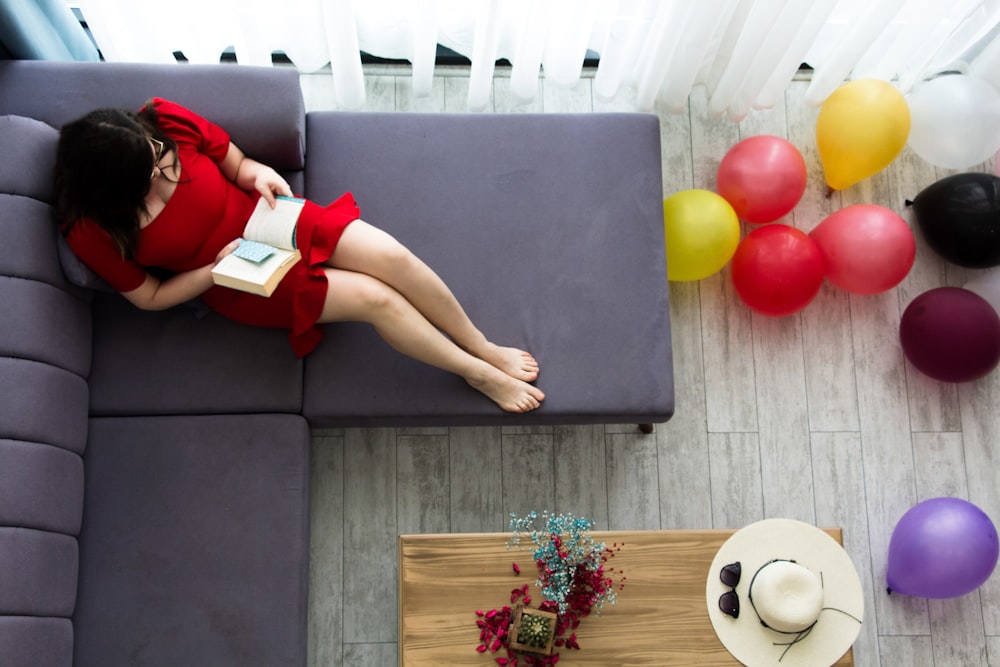 a woman in a red dress sitting on a couch