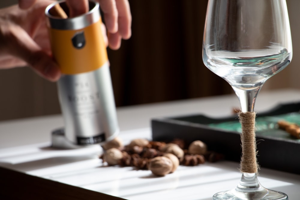 a person is pouring a drink into a wine glass