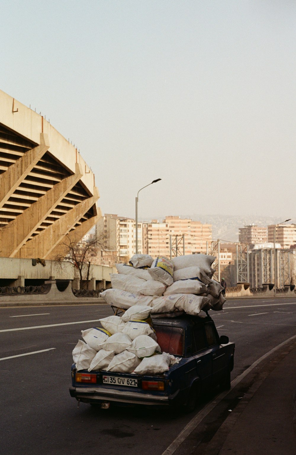 a truck loaded with bags driving down a street