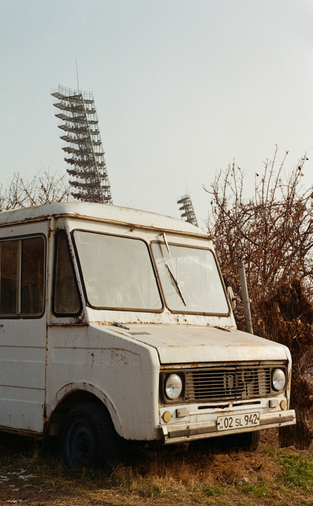 an old white truck parked in a field