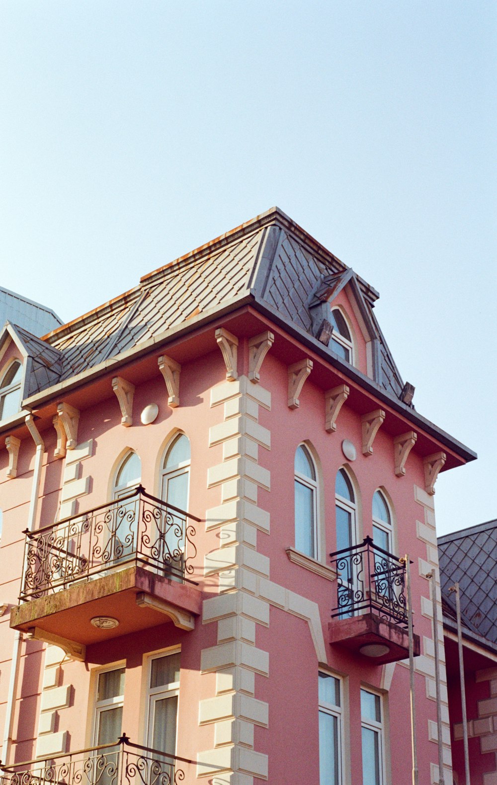 a pink building with a balcony and balconies