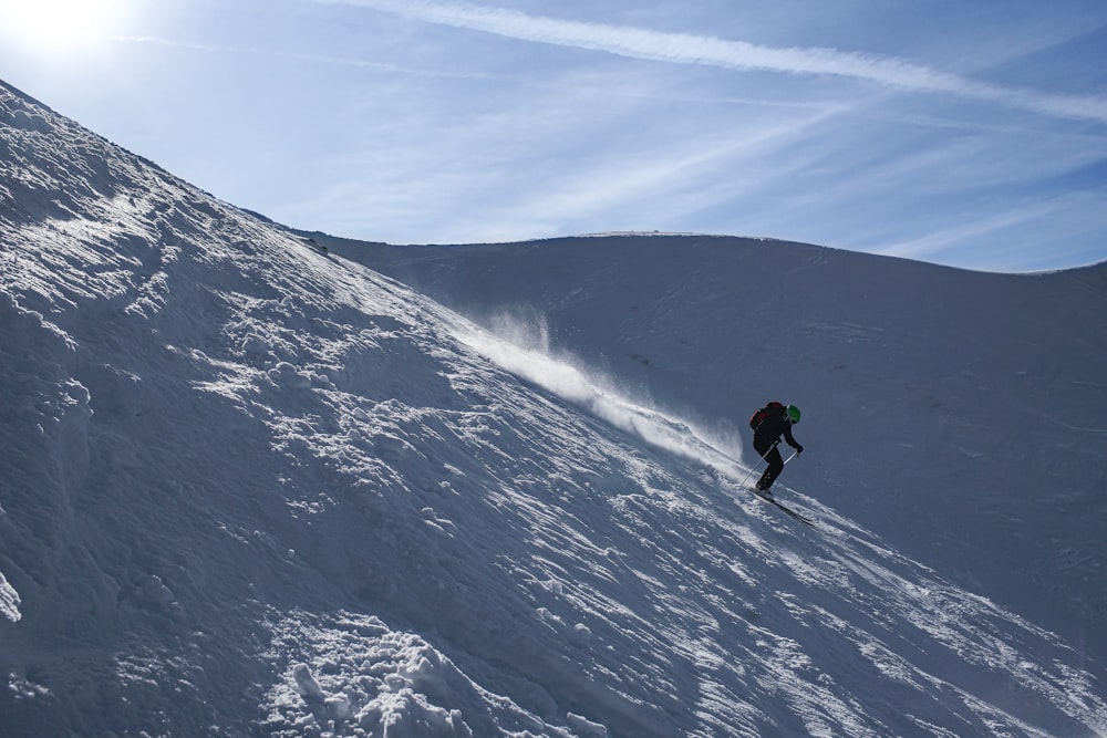 a person on a snowboard going down a snowy hill