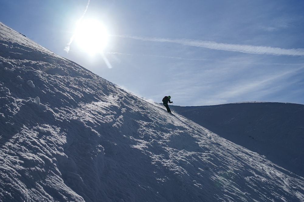 a person on a snowboard going down a snowy hill