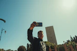 A joyful traveler capturing a selfie with a famous city landmark in the background.
