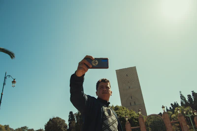 A joyful traveler capturing a selfie with a famous city landmark in the background.