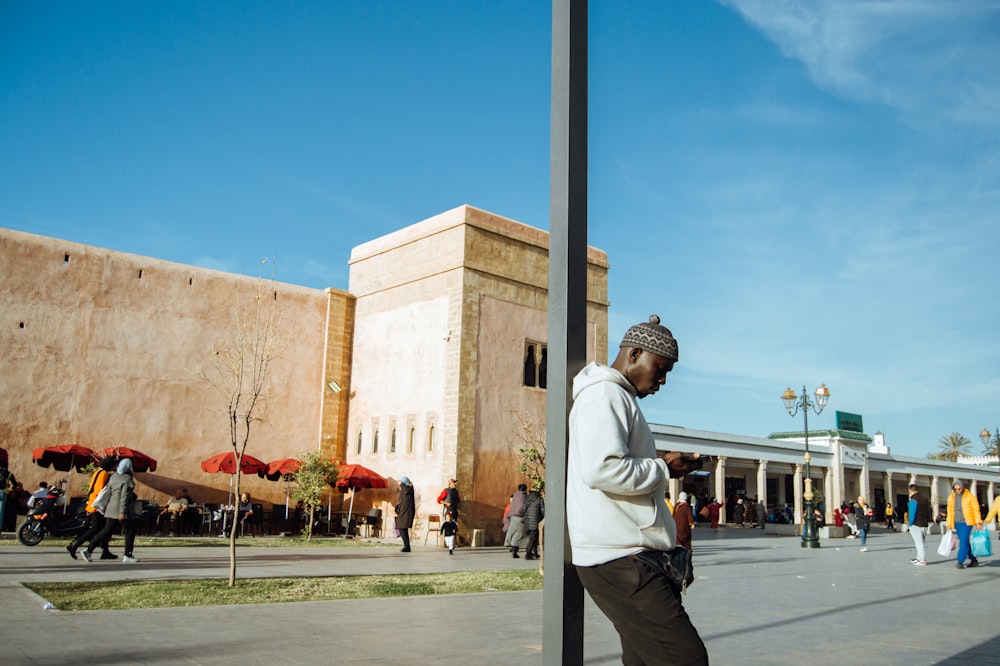 a man standing next to a street sign in front of a building