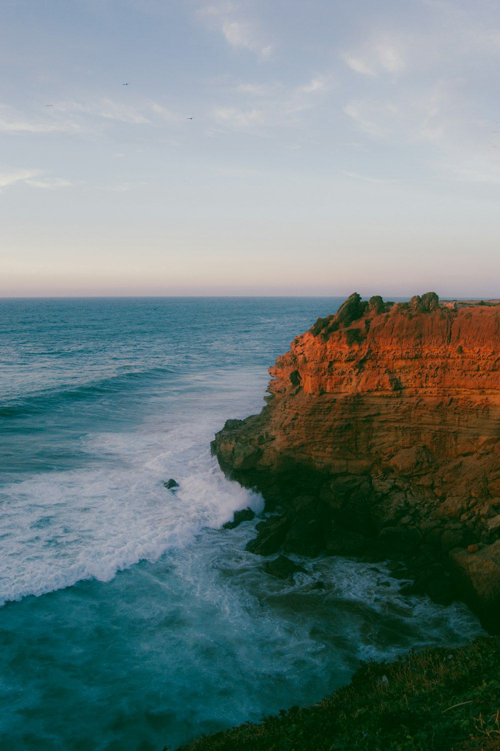 a rocky cliff overlooks a body of water