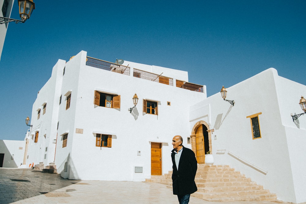 a man standing in front of a white building