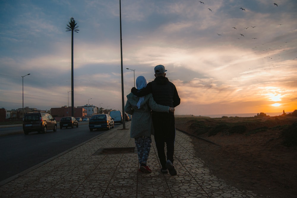 a couple of people standing on a sidewalk